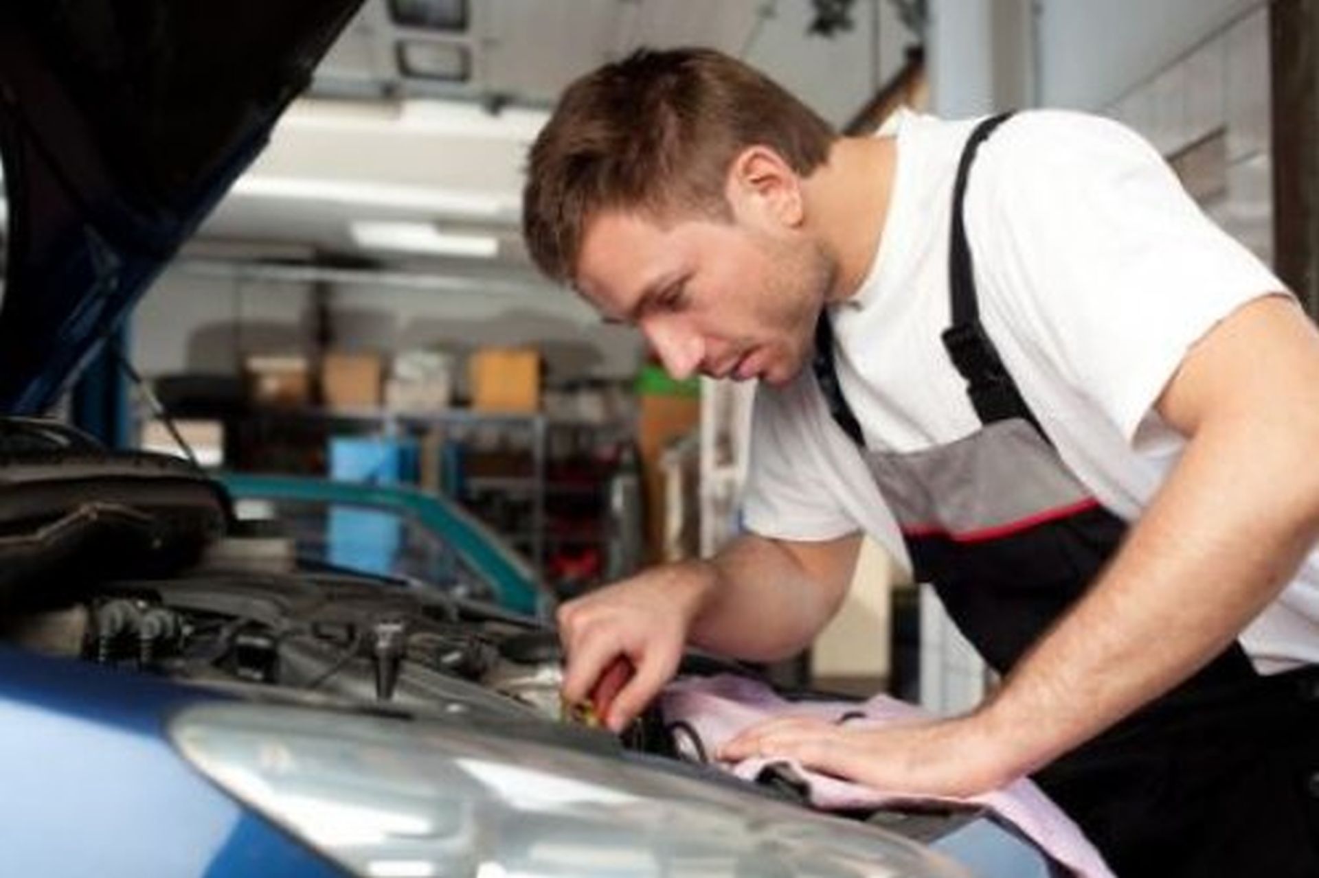 Mechanic fixes. Автомеханик чинит машину. Мужчина чинит машину. Механик автосервис. Техобслуживание автомобиля.